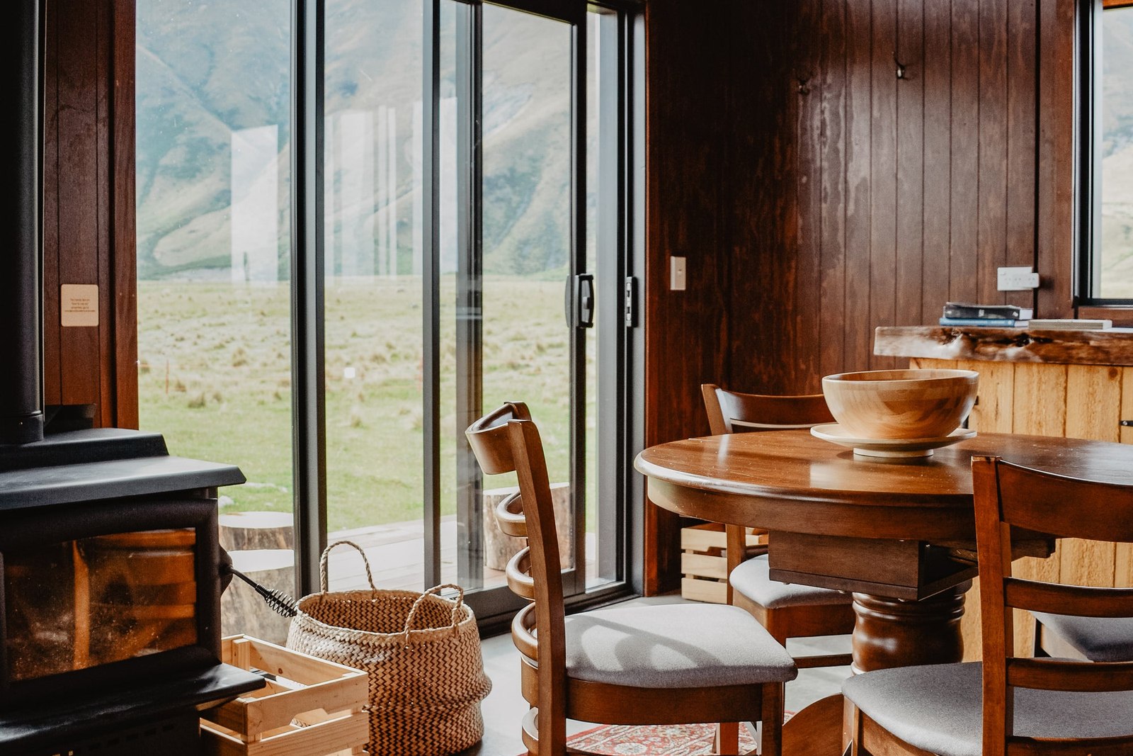 Open glazed doorway beside a timber table and woven basket