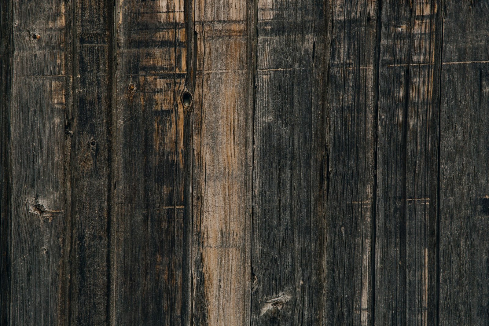 Dark weathered timber boards with visible grain and wear