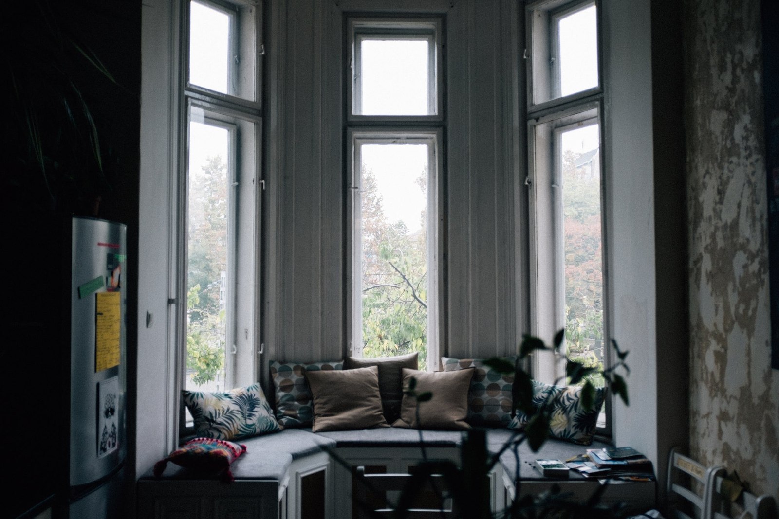 Deep bay windows surrounding a sofa in a softly lit room